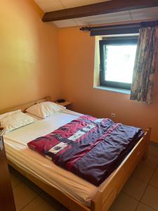 łóżko w sypialni z oknem w obiekcie Le Hérou w mieście Houffalize