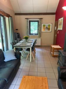 a living room with a table and a couch at Le Hérou in Houffalize +19 photos