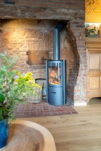 a stove in a brick wall with a fireplace at Au four et au jardin in Namur