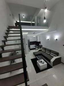 K&K Luxury Loft Apartment في سيريس: غرفة معيشة مع أريكة ودرج
