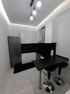 a kitchen with a black table and black chairs at K&K Luxury Loft Apartment in Serres