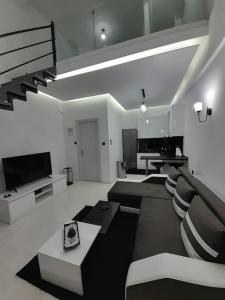 K&K Luxury Loft Apartment في سيريس: غرفة معيشة مع أريكة وتلفزيون