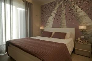 トレヴィニャーノ・ロマーノにあるCasa Vacanze i Melograniのベッドルーム1室(木の壁画のある大型ベッド1台付)