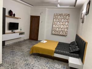 a bedroom with a bed and a television in it at Shree Bharadi Home Stay in Alibaug