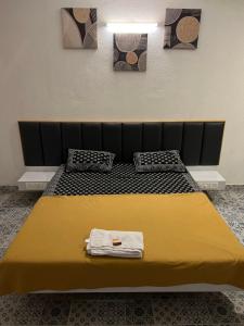 1 dormitorio con 1 cama con manta amarilla en Shree Bharadi Home Stay, en Alibaug