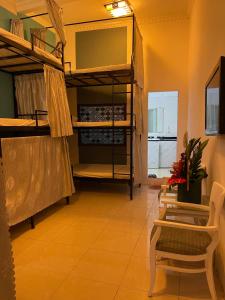 a room with bunk beds and a table and chairs at Hanoi Jade Hostel in Hanoi