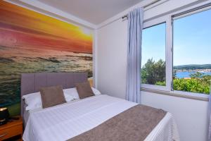 1 dormitorio con cama y ventana grande en Holiday Villa Perna, en Orebić