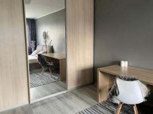 ein Schlafzimmer mit einem Spiegel, einem Schreibtisch und einem Stuhl in der Unterkunft Милая квартира в 7 км от Таллинна in Maardu