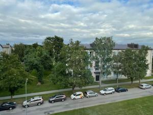 eine Gruppe von Autos, die auf einer Straße vor einem Gebäude geparkt sind in der Unterkunft Милая квартира в 7 км от Таллинна in Maardu