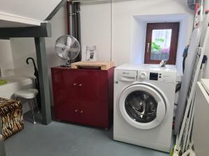 a laundry room with a washing machine and a fan at Gästeapartment Pfaff in Rottweil