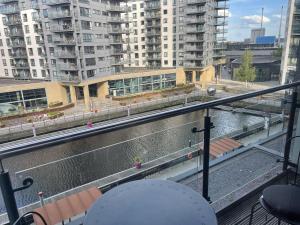 a balcony with a view of a river and buildings at Deluxe City Apt, Beautiful River View&Free Parking in Leeds