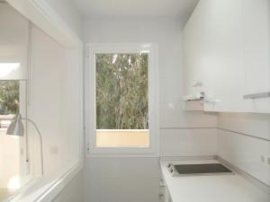 a white kitchen with a window and a sink at APARTAMENTOS DOÑA CARMEN - Alojamiento en Málaga capital in Málaga +43 photos