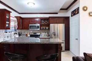 a kitchen with wooden cabinets and a refrigerator at Loft - Sleeps 4 - Parking - Balcony in Kingston