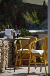 stół z 2 krzesłami i 2 butelki wina w obiekcie Panorama w mieście Simi