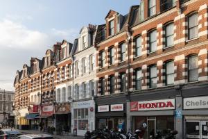 a row of buildings on a city street with motorcycles at The Fulham Secret - Classy 5BDR Apartment in London