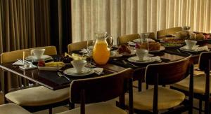 a dining room table with food and orange juice on it at Quinta Vale das Papas in Casal de Loivos