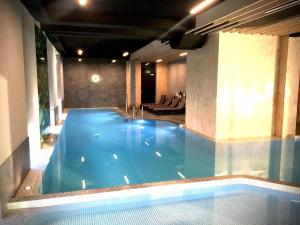 a large swimming pool in a building with a pool at BalticSea Apartamenty in Sarbinowo