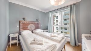 a bedroom with a bed and a large window at Apartamenty Sun & Snow Bastion Gdańsk in Gdańsk