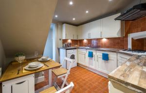 uma cozinha com armários brancos e uma mesa e cadeiras em Taylors Townhouse em Royal Tunbridge Wells