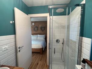 a bathroom with a shower and a bed in it at La Mucca Pelosa B&B in Jovencan