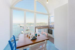 a dining room with a table and a large window at TORRETTA CORRICELLA - Punta Miseno in Procida