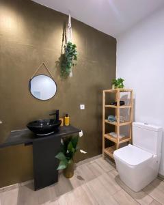 a bathroom with a black sink and a toilet at Hostal Orange Vibes in Paterna