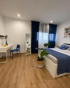 a bedroom with a bed and a desk with a plant at Hostal Orange Vibes in Paterna