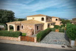 a large house with a fence in front of it at Ville del Mar in San Teodoro