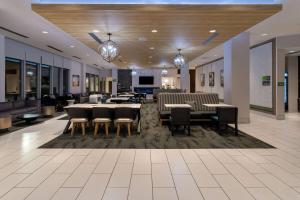un vestíbulo con mesas y sillas en un edificio en La Quinta Inn & Suites by Wyndham Maricopa Copper Sky, en Maricopa