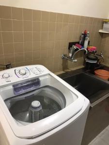a washing machine in a sink in a kitchen at Residencial Jardim Curitiba in Curitiba