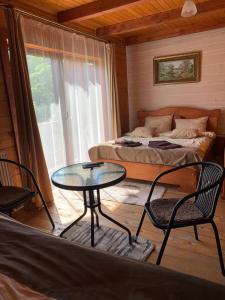 1 dormitorio con 1 cama, mesa y sillas en Готель Bliznuky, en Vorokhta
