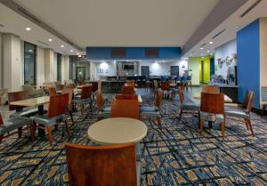 a dining room with tables and chairs and a cafeteria at La Quinta Inn & Suites by Wyndham Lubbock Southwest in Lubbock