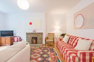 a living room with a couch and a fireplace at Poplar Farm House in Kent
