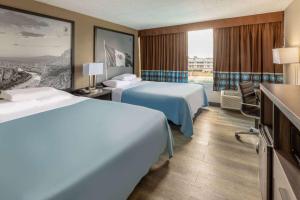 a hotel room with two beds and a window at Super 8 by Wyndham Laredo in Laredo