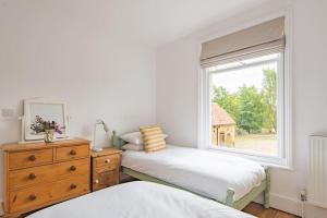 a bedroom with two beds and a window at Poplar Farm House in Kent