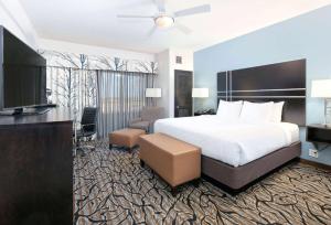 a hotel room with a bed and a flat screen tv at La Quinta Inn & Suites by Wyndham Lubbock Southwest in Lubbock