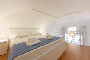 ein weißes Schlafzimmer mit einem Bett mit Handtüchern darauf in der Unterkunft TORRETTA CORRICELLA - Punta Miseno in Procida