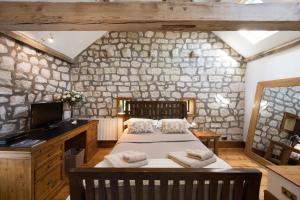 a bedroom with a bed and a stone wall at Crow House Barn in Copgrove