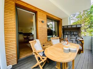 une terrasse en bois avec une table et des chaises en bois dans l'établissement Strandkorb & Mee(h)r, à Baabe