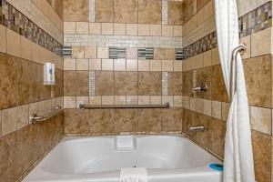 シェルビービルにあるEcono Lodgeのタイル張りのバスルーム(バスタブ付)