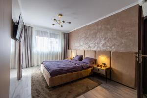 Un dormitorio con una cama grande y una ventana en Arad Residence - DeLuxe Blue Apartment, en Arad