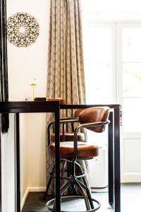 einen Schreibtisch mit einem Stuhl neben einem Fenster in der Unterkunft 2 Suites romantiques avec spa privatif et 1 loft avec billard proche de Toulouse in Verfeil