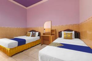 Säng eller sängar i ett rum på SPOT ON 91930 Hotel Citra Dewi 4 Manunggal