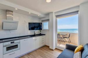 cocina blanca con vistas al océano en 797 Holiday Rentals - Benalbeach- Moderno piso para 5 con vistas al mar, en Benalmádena