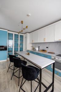 Arad Residence - DeLuxe Blue Apartment في أراد: مطبخ فيه طاولة وكراسي
