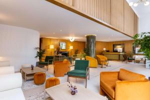 een lobby met oranje en groene stoelen en tafels bij Best Western Plus Casablanca City Center in Casablanca