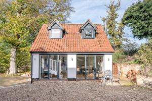 a small cottage with an orange roof and windows at Little Honey Pot in Saxmundham