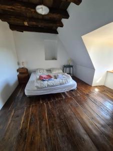a bed in a room with a wooden floor at Maison typique Auvergnate, piscine et four à pain in Saint-Christophe-les-Gorges +33 photos