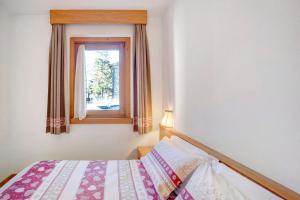 a small bedroom with a bed and a window at Baita al Pian Ginepro in Bormio