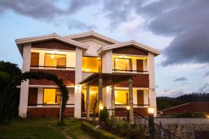 a house with lights on in front of it at Western Valley Resorts in Ooty